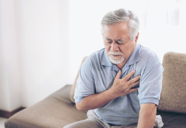 elderly man holding chest in pain - heart and vascular institute