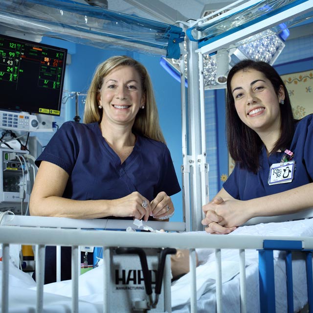 nurses smiling and posing in hospital room
