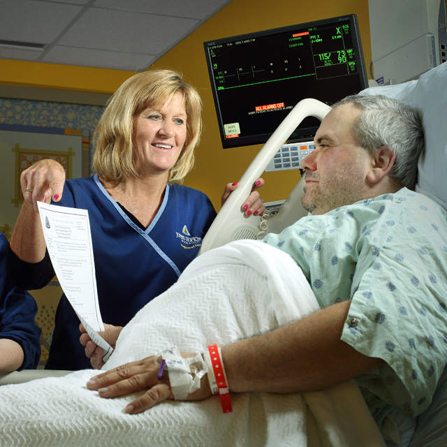 The photo shows nurses working with a patient to prevent blood clots. 