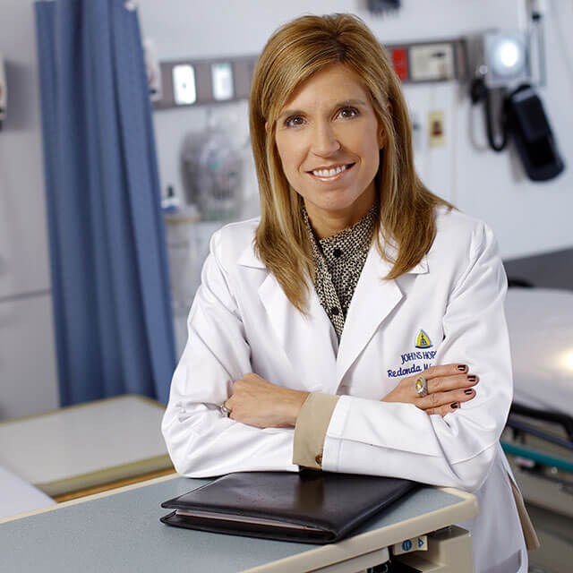 A photo shows Redonda Miller in a white coat. 
