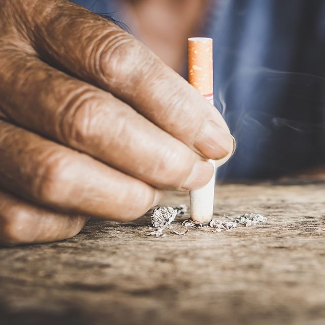 Image of a hand stubbing out a half-smoked cigarette. 