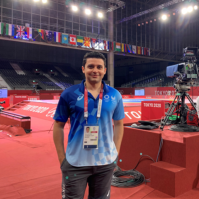 Photo of Emam standing in front of olympic stage.
