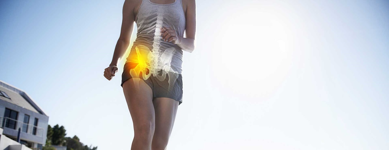 Woman with hip pain while walking on a trail.
