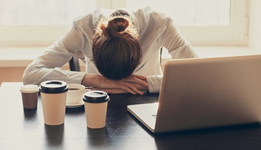 woman tired at desk - chronic fatigue syndrome