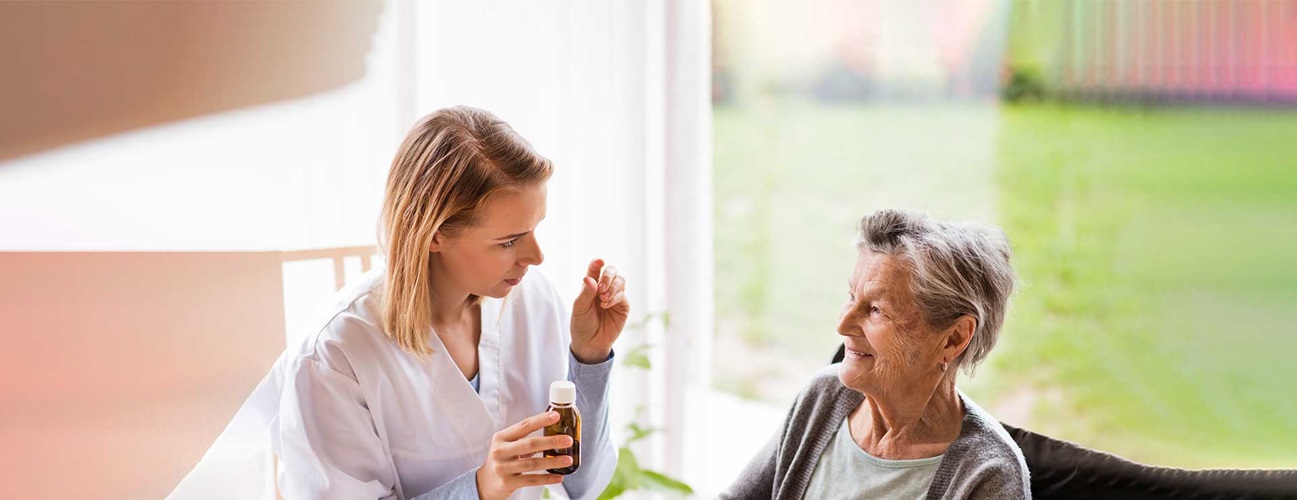 doctor holding medicine talking to older lady