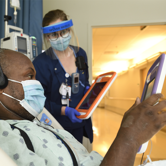 A photo shows a patient in the hospital using a tablet.