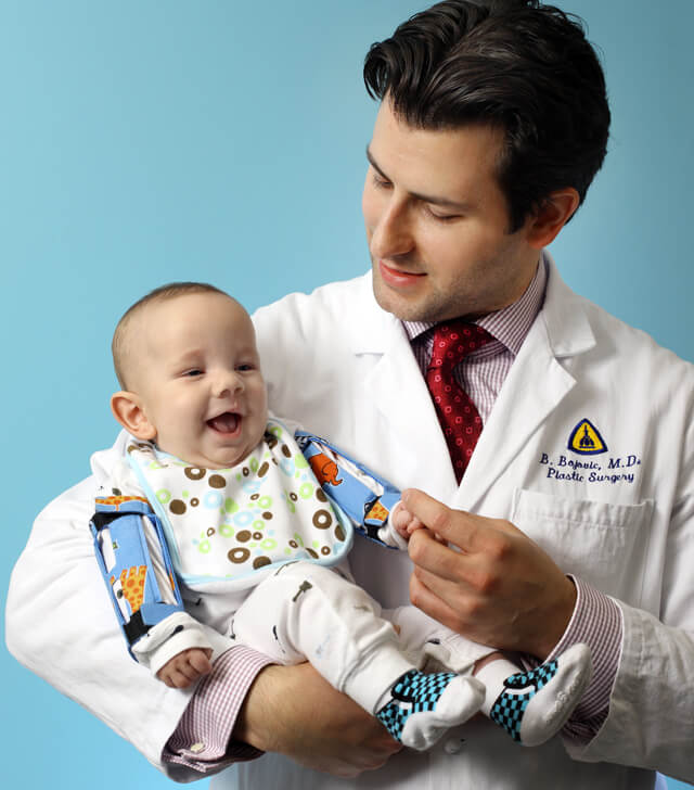 Dr. Bojovic holding a baby.