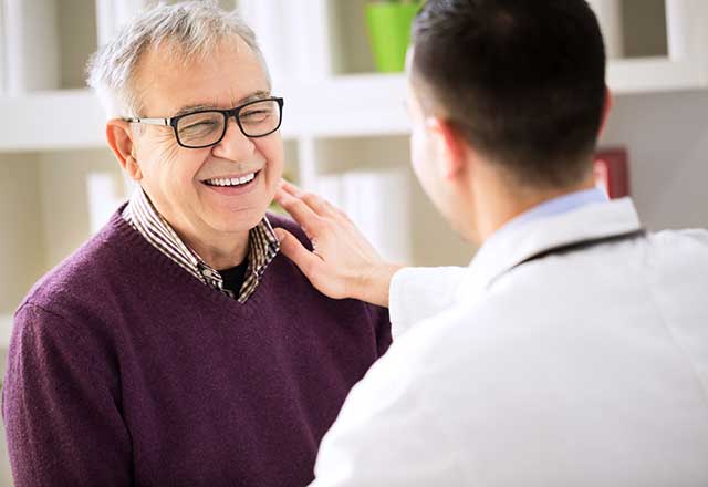 Younger doctor speaking with an older male patient