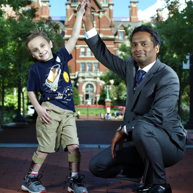Dr. Varghese high-fiving a young patient