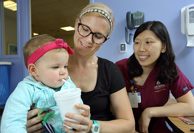 a speech-language pathologist works with a baby and her mother on swallowing