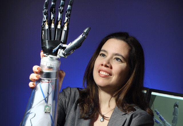 Dr. Marlis Gonzalez-Fernandez holding a prosthetic arm.