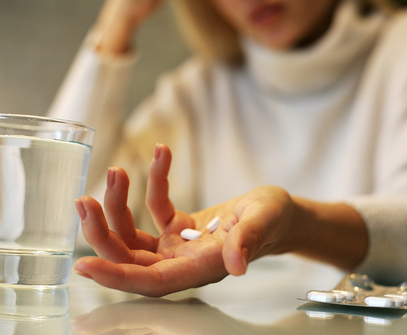 a frustrated woman holding pills