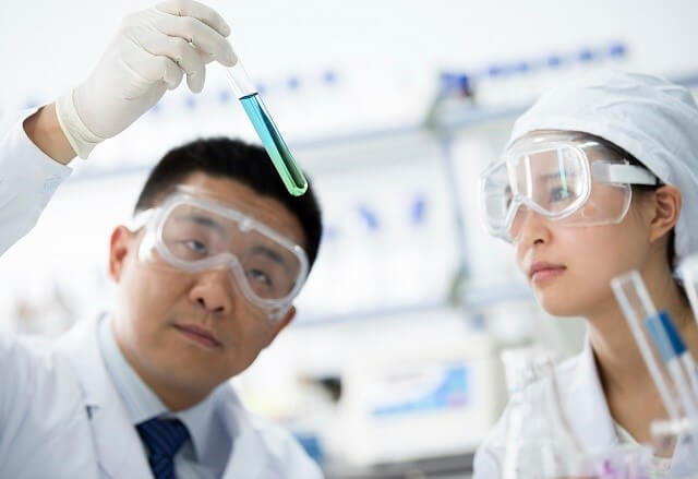 Two researchers looking at vials of liquid