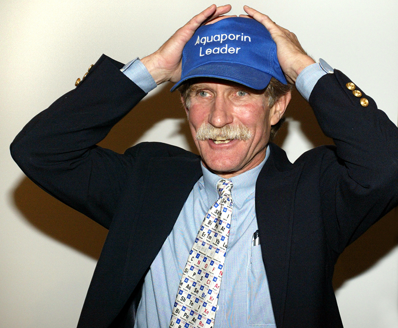 Peter Agre wearing a hat that says, "Aquaporin Leader."