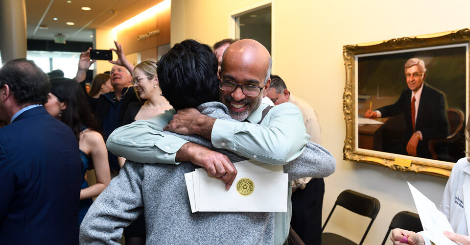 A celebratory hug is shared.