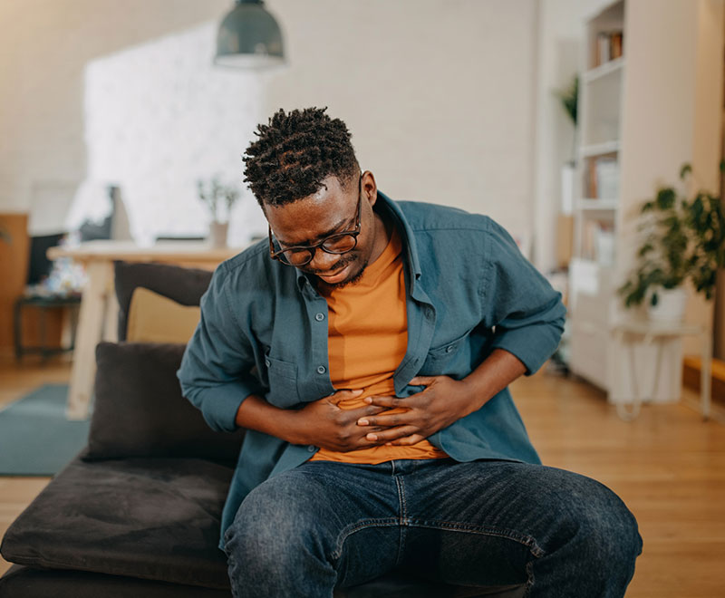 a man holds his stomach in pain