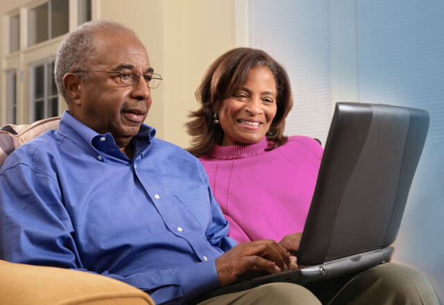 Couple sitting on a couch using a computer together