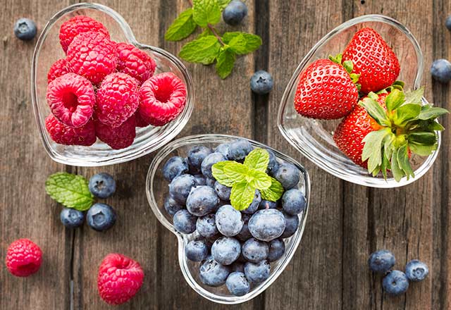 Berries in heart-shaped glass bowls. 