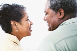 african american man and african american woman looking at each other smiling