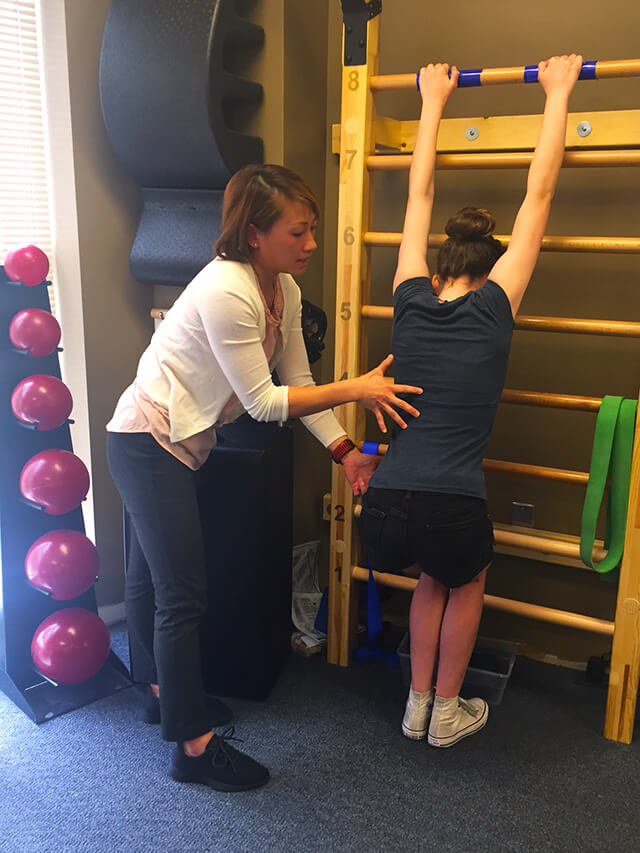 Lien helps Sophie with Schroth exercises