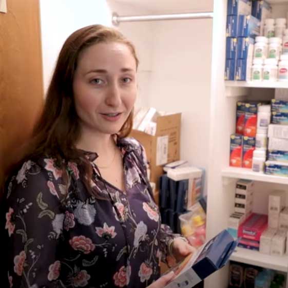 Elana giving a tour of the Asylee facility with a supply closet in the background