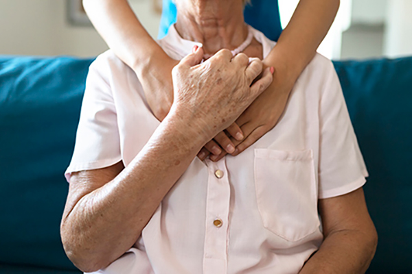 Caregiver hugging senior