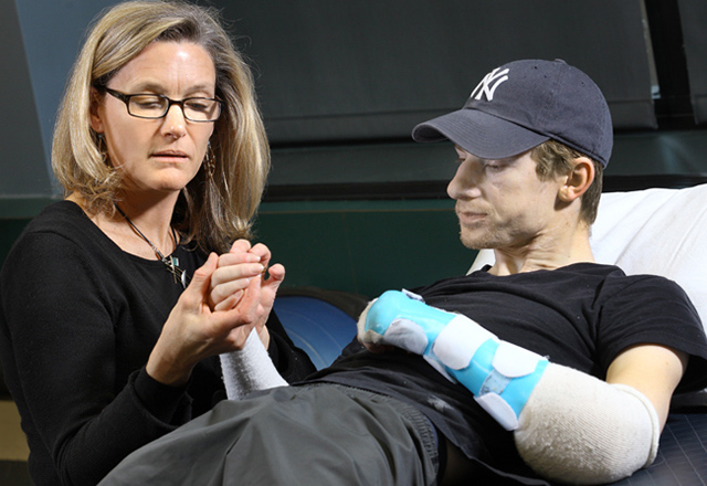 Healthcare professional helping a patient with an arm prosthetic