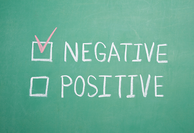 chalkboard with the word negative and positive written with checkmark by negative