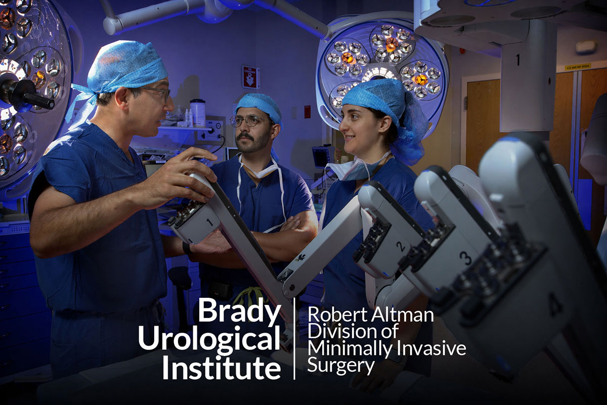 Doctor Allaf operates a surgical robot while two other doctors observe. The logo text reads Brady Urological Institute Robert Altman Division of Minimally Invasive Surgery