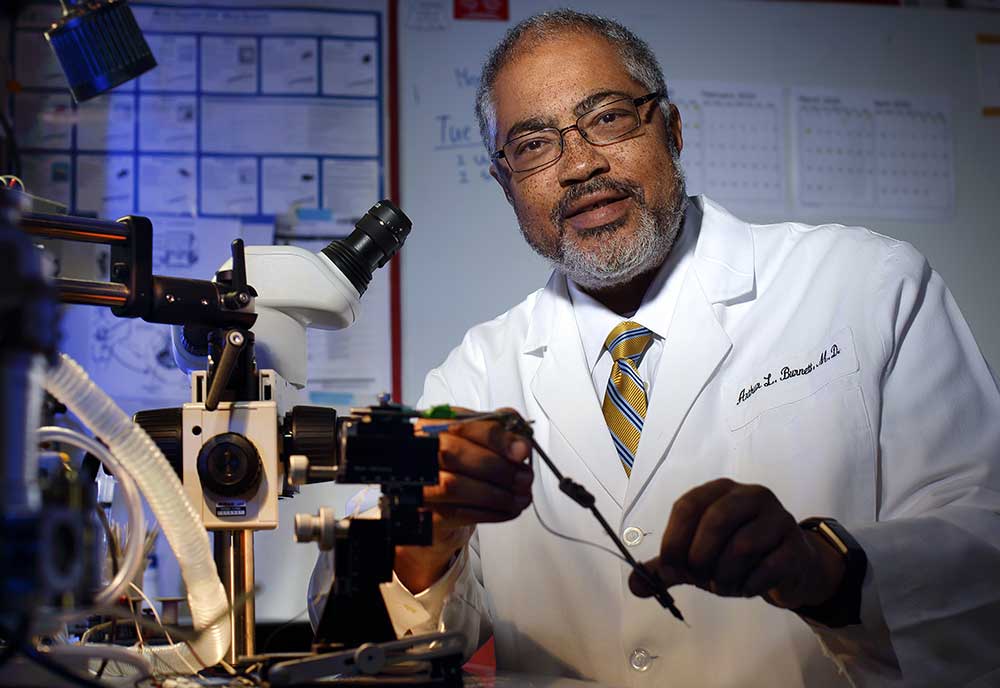 Doctor Burnett in the lab with a microscope