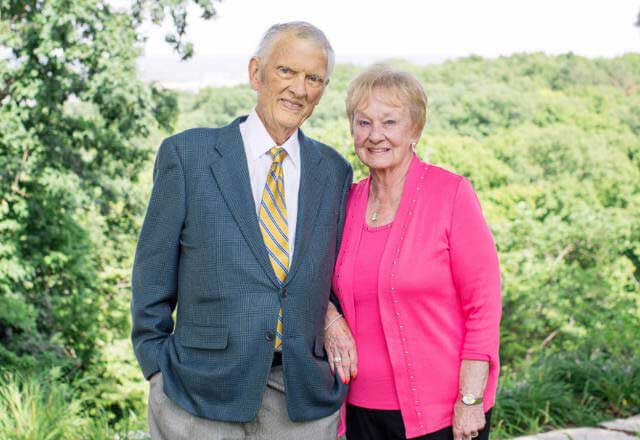 Gerald and Helen Stephens smiling together against a lush green landscape