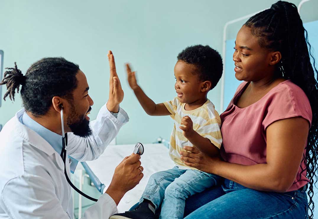Friendly doctor gives a young patient a high five