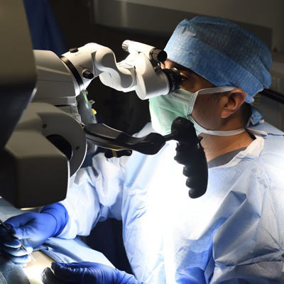 Johns hopkins assistant professor of urology and male infertility specialist amin herati looks through a state of the art microscope during surgery