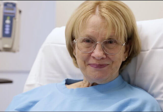 Sue smiles in hospital bed