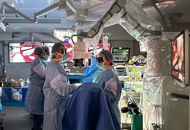 Brain tumor surgeons in the operating room with robotic assistance