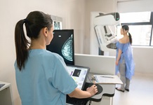 tech performs mammogram