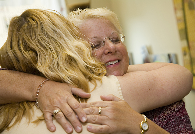 two women hug during support group