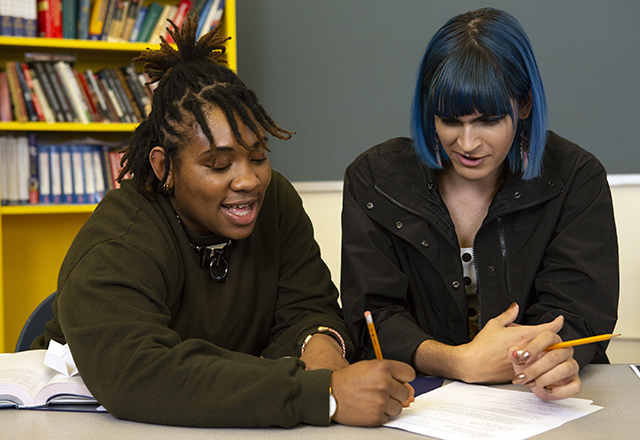 Two nonbinary youths work on homework.