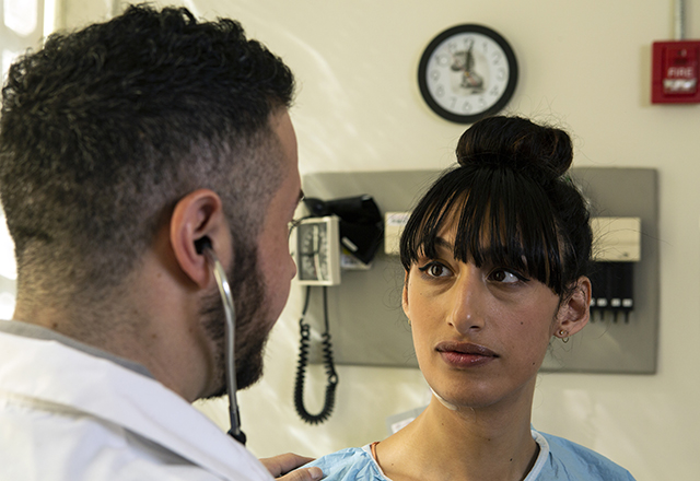 A transgender woman speaks with a doctor.