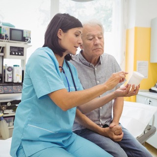 Physician speaking with patient in care room