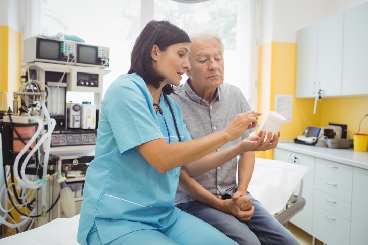 Physician speaking with patient in care room