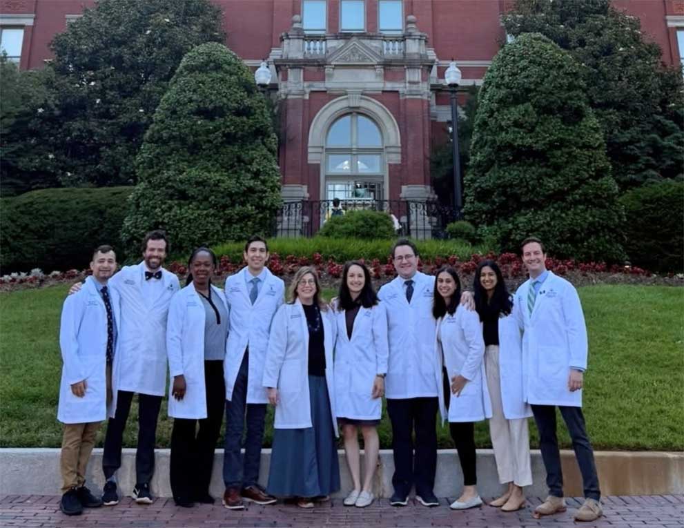 Fellows smiling together in front of the Johns Hopkins dome building