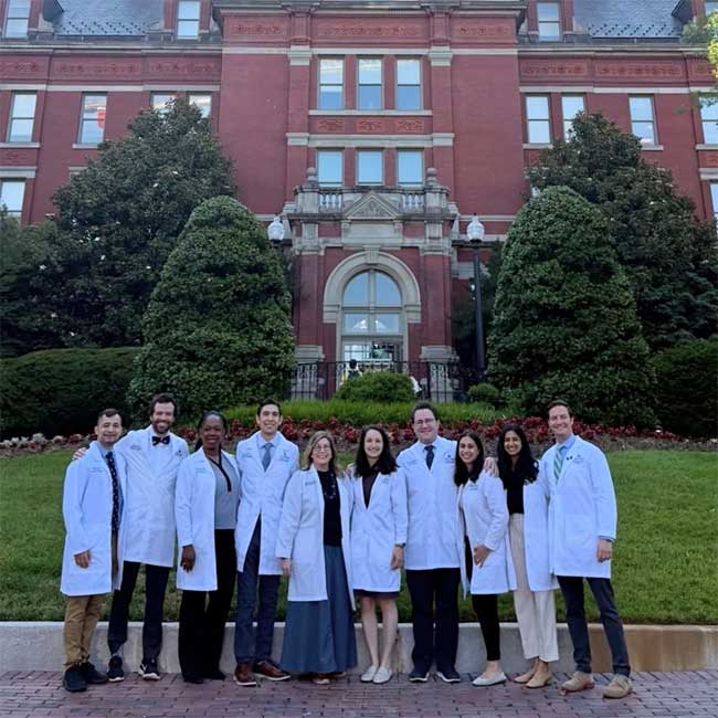 Fellows smiling together in front of the Johns Hopkins dome building