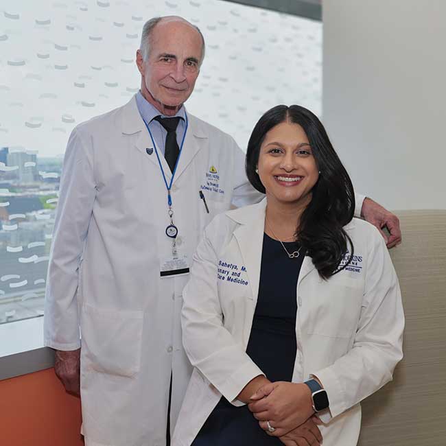 Dr. Sahetya and Dr. Brower in white coats smiling together