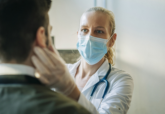 Masked provider checking a patient