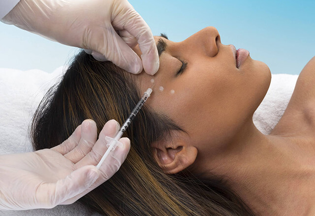 A woman receives an injectable neuromodulator treatment.