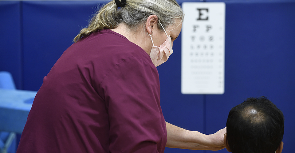 A health care worker conducts a vision test.