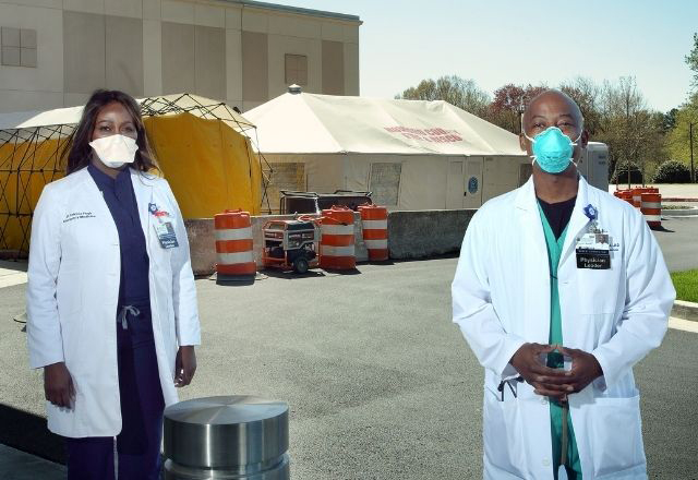 two physicians outside of a testing tent