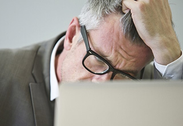 Man in front of laptop dealing with stress
