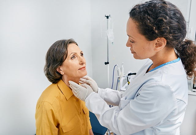 doctor checking woman's throat